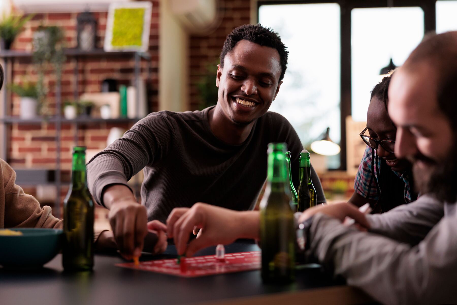 Amigos sorrindo enquanto jogam um jogo de tabuleiro no bar